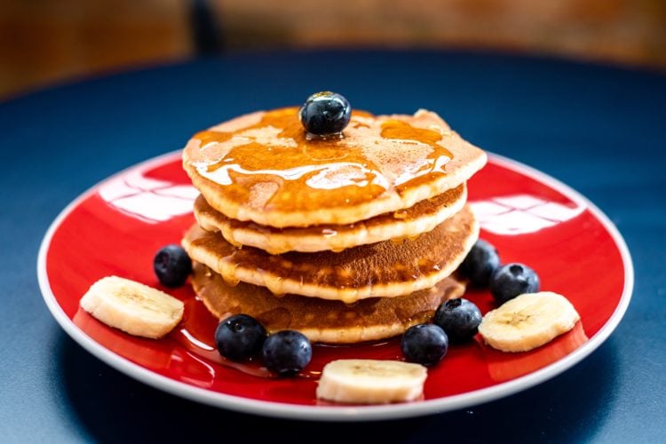 baked pancakes with blueberry and slice of banana in a red plate