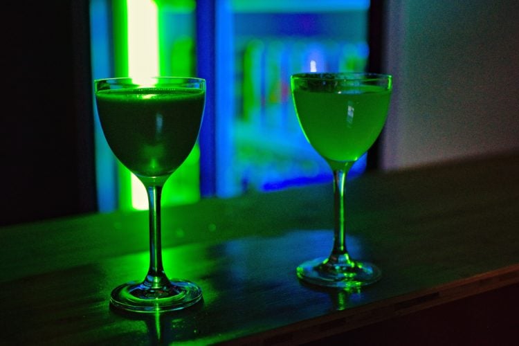 two green cocktails on a bar