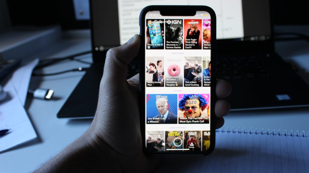 person holding black android smartphone with snapchat homescreen displayed
