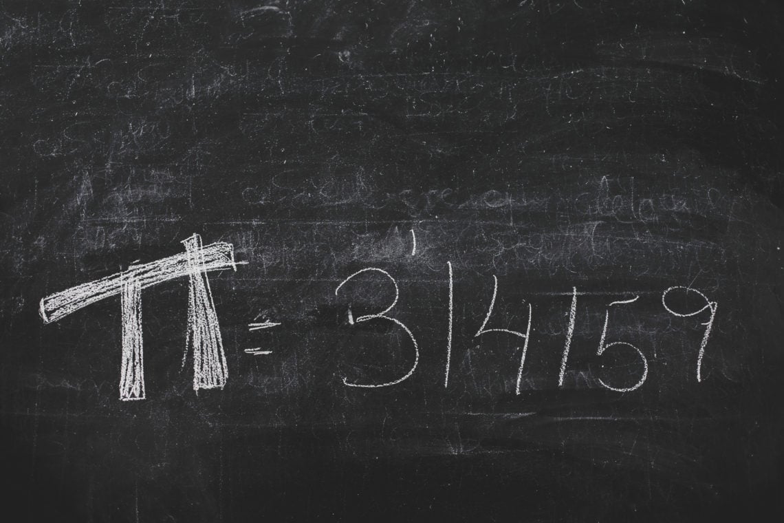 Hand-written Pi numbers on black chalkboard