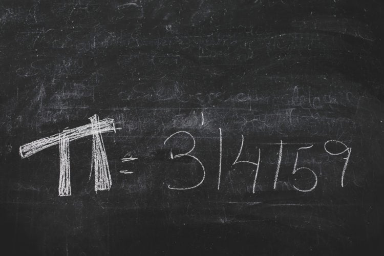 Hand-written Pi numbers on black chalkboard