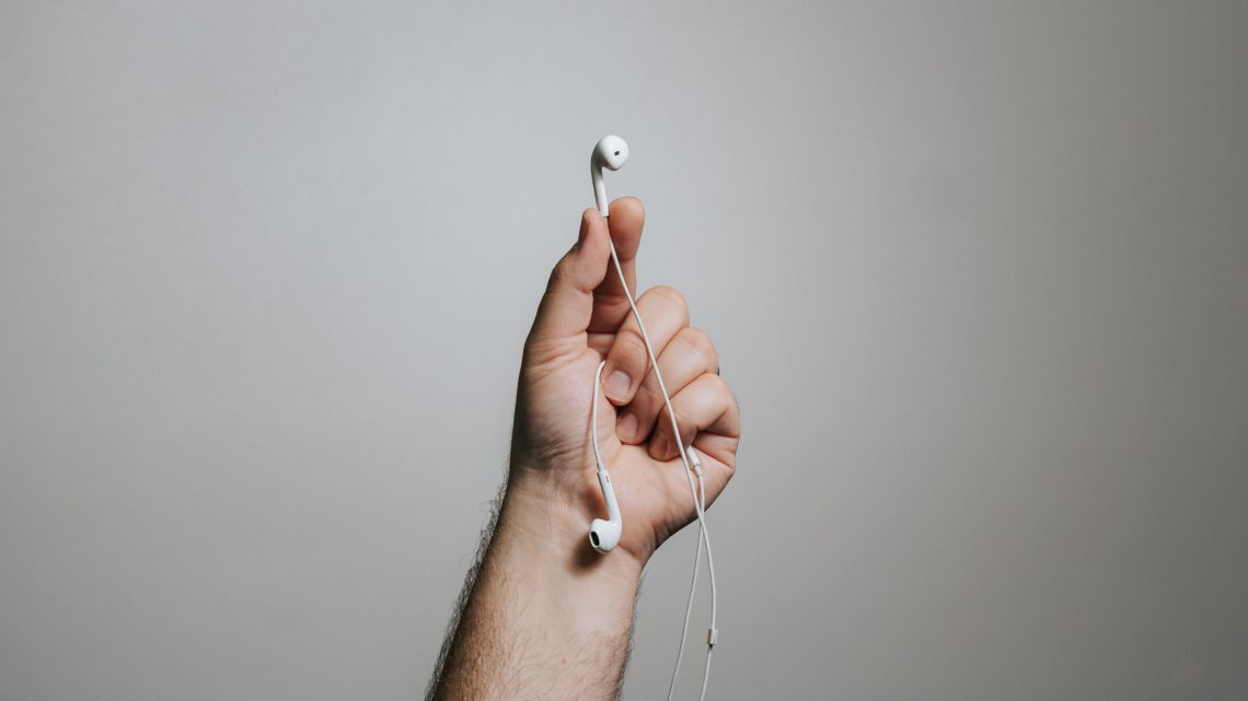 person holding white apple earpods