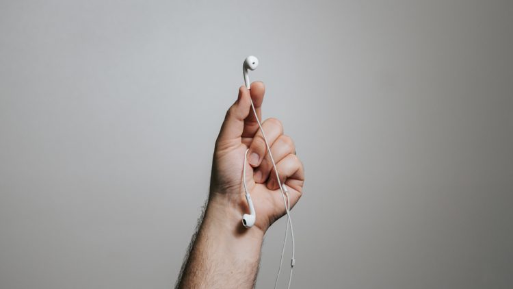 person holding white apple earpods