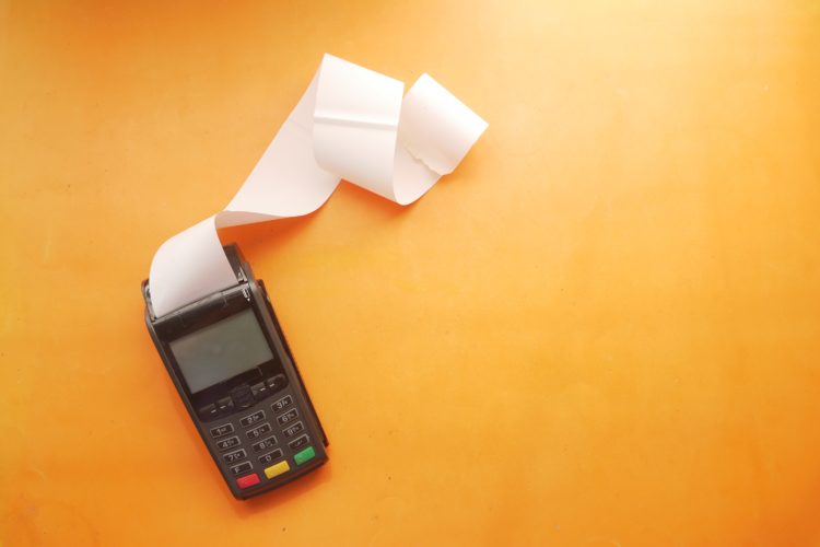 calculator with receipt on orange background