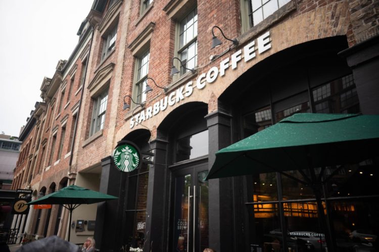 outside of brick starbucks building with two green parasols outside