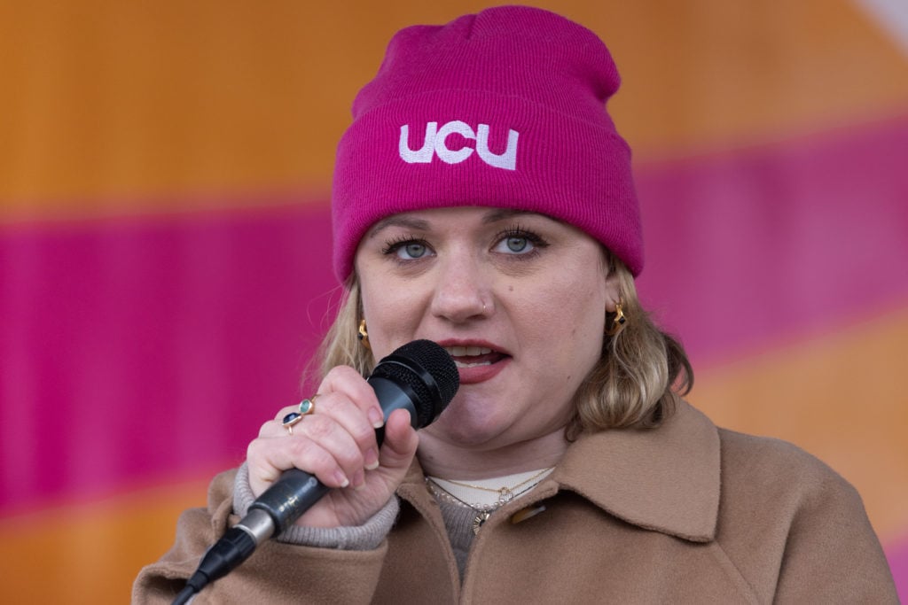 close up of Jo Grady in pink UCU hat holding microphone to mouth