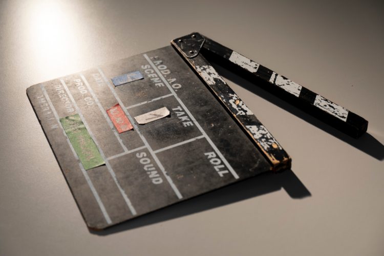 black clapper board lying on white floor with mouth open
