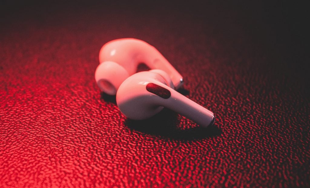 airpods lying on leather with red lighting