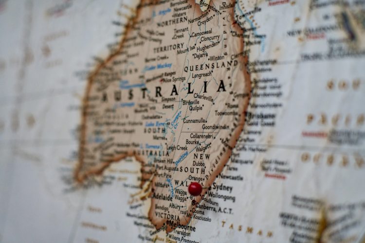 map of australia in brown  with white sea background and red pin in bottom corner