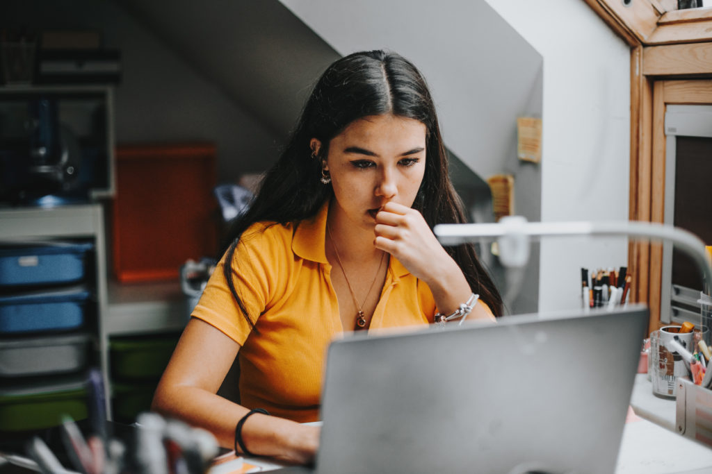 female student in yellow top studying from computer