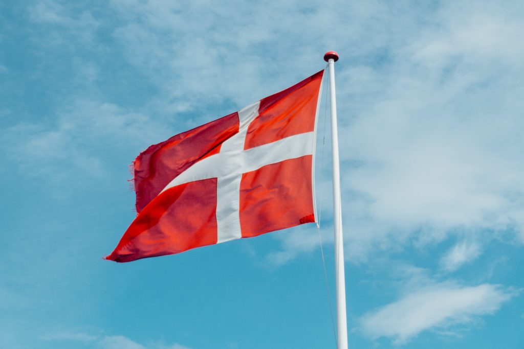 danish flag on flag pole against blue sky