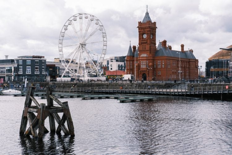 picture overlooking cardiff bay with ferris wheel and large orange pierhead building