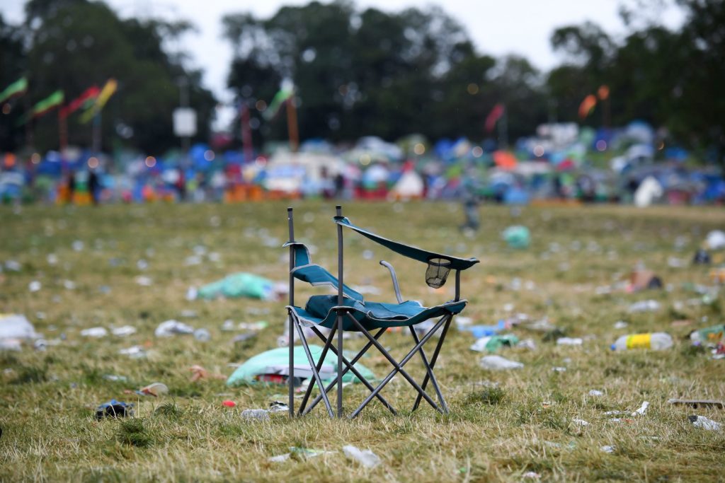 Broken camping chair and a field covered in rubbish a Glastonbury Festival