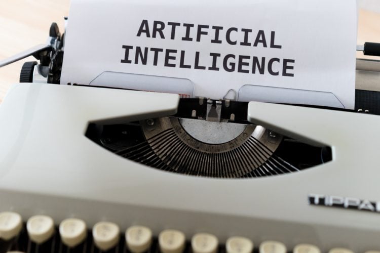 close up of white typewriter with piece of paper with 'artificial intelligence' on