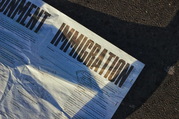 white paper on ground with 'immigration' in bold